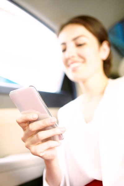 iPhoneを操作する外国人女性のイメージ
